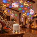 Salón con muñecos de nieve, renos y copos de colores proyectados en techo y paredes